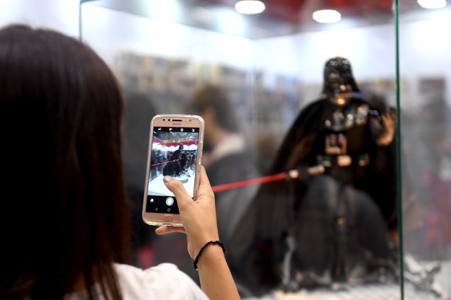 Fã de Star Wars fotografa boneco representativo da personagem Darth Vader, o item mais caro da loja, que custa cerca de três mil reais