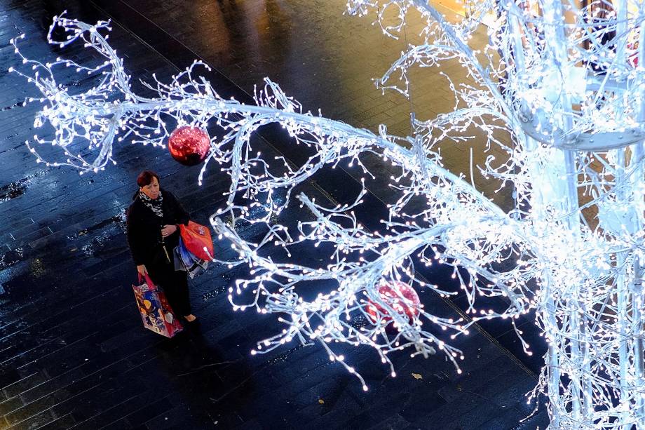 Mulher carrega suas sacolas de compras enquanto passa embaixo das decorações de Natal em Liverpool, na Inglaterra - 27/11/2017