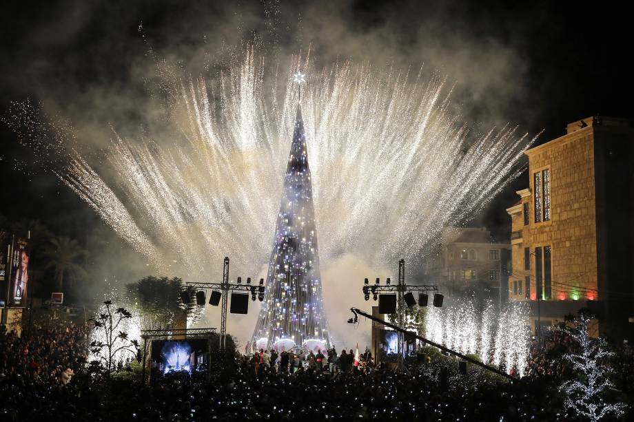 Pessoas se reúnem e usam celulares para filmar os fogos de artifício em torno de uma árvore de Natal na cidade litorânea de Byblos, a norte de Beirute no Líbano - 30/11/2017