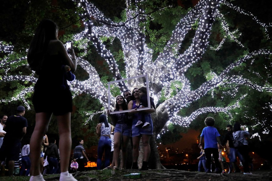 Família faz pose para foto perto de árvores decoradas com luzes de Natal no Parque do Ibirapuera em São Paulo - 03/12/2017