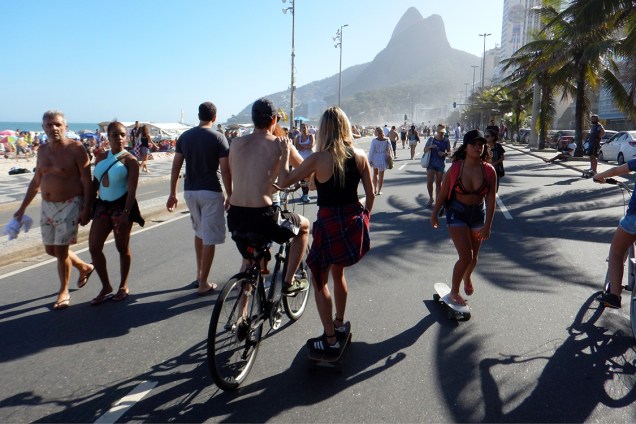 Pessoas caminham no calçadão da praia do Leblon, no Rio de Janeiro