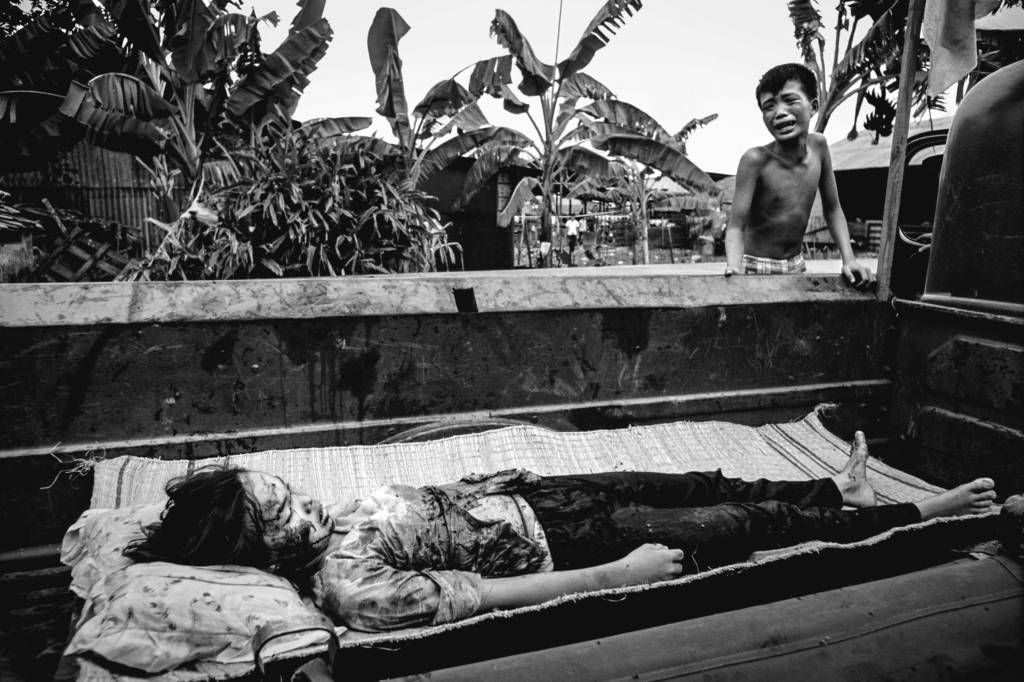 Menino vietnamita chora ao ver o corpo da irmã