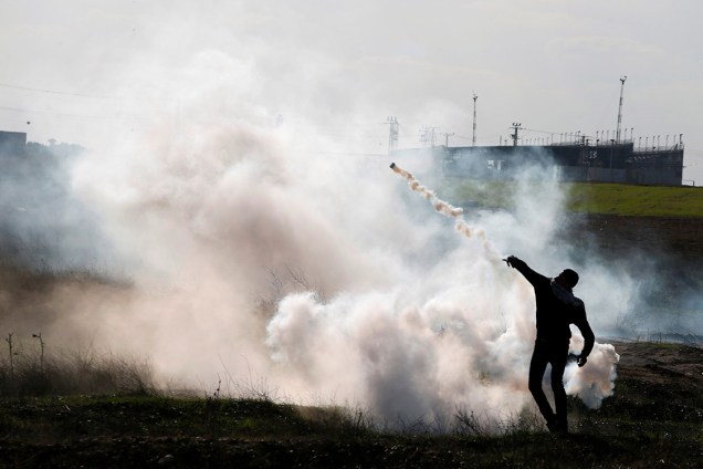Manifestante palestino atira de volta uma bomba de gás lacrimogênio contra as tropas israelenses, durante protesto intitulado  "dia de raiva", em resposta à atitute do presidente Donald Trump de reconhecer Jerusalém como capital de Israel - 08/12/2017