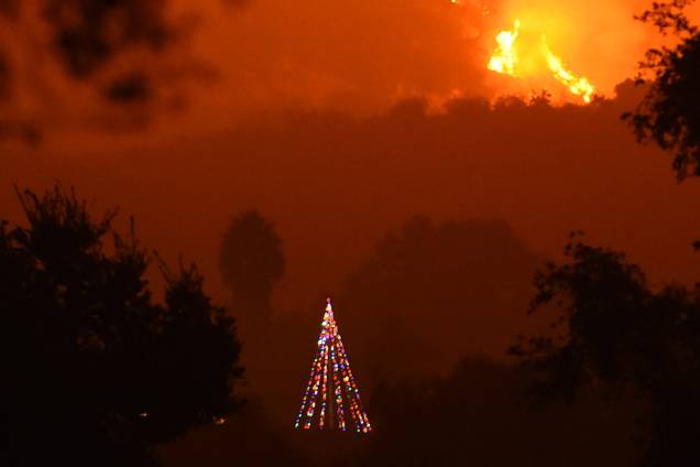 Incêndio atinge as colina da cidade de Carpinteria, atrás de uma árvore de Natal, na Califórnia. As chamas já consumiram mais de 230.000 hectares e é o quinto maior incêndio da história do estado Incêndio atinge as colina da cidade de Carpinteria, atrás de uma árvore de Natal, na Califórnia. As chamas já consumiram mais de 230.000 hectares e é o quinto maior incêndio da história do estado