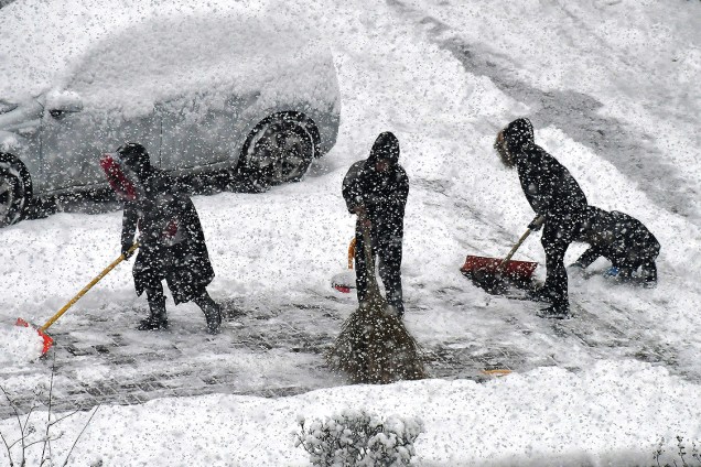 Funcionários públicos trabalham retirando neve das vias em Yantai, na China - 12/12/2017