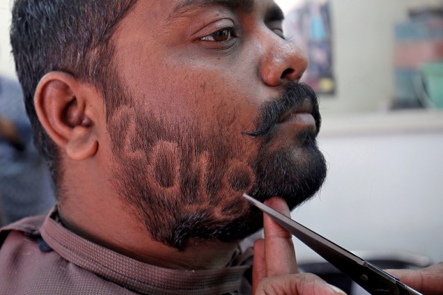 Um homem apara a barba para mostrar o número 2018 em homenagem ao Ano Novo, dentro de uma barbearia em Ahmedabad, na Índia - 29/12/2017