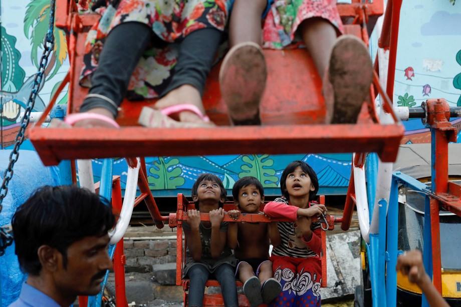 Crianças de uma favela em Mumbai, andam em uma roda gigante manual na Índia - 27/12/2017