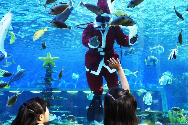 Mergulhador vestido de Papai Noel interage com crianças dentro de um aquário de Manila, nas Filipinas - 15/12/2017