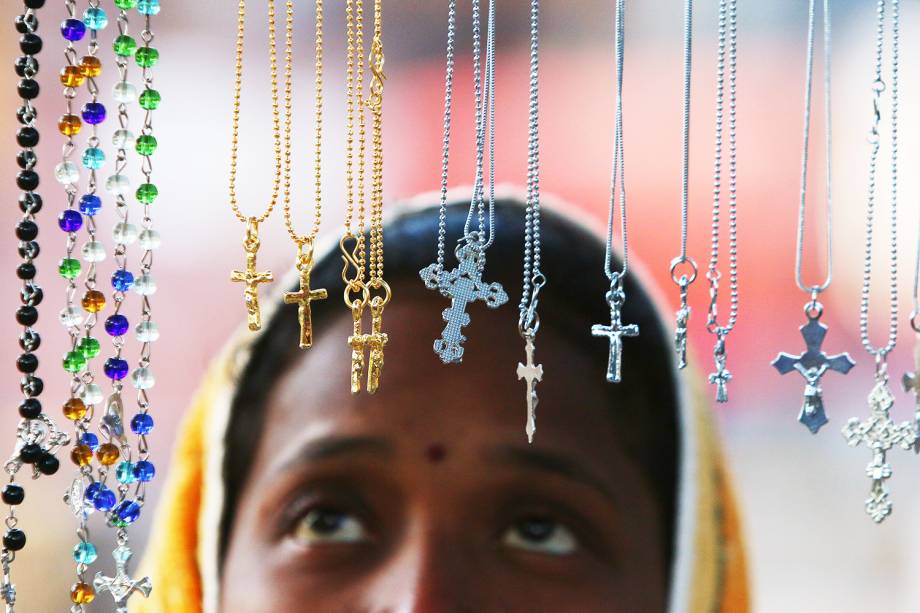 Mulher observa correntes com cruz durante as celebrações de Natal em Chandigarh, na Índia - 25/12/2017