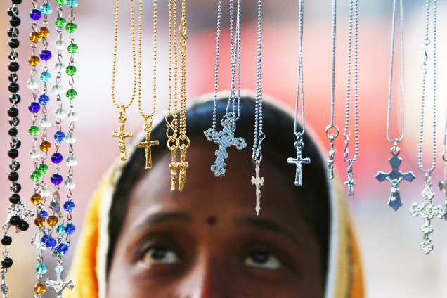 Mulher observa correntes com cruz durante as celebrações de Natal em Chandigarh, na Índia - 25/12/2017