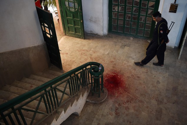 Um policial paquistanês observa uma mancha de sangue no chão do Instituto de Treinamento da Agricultura, após um ataque de militantes do Talibã em Peshawar. As autoridades confirmaram nove mortos e dezenas de feridos, vitmas do Talibã enquanto comemoravam o aniversário do profeta Maomé - 01/12/2017