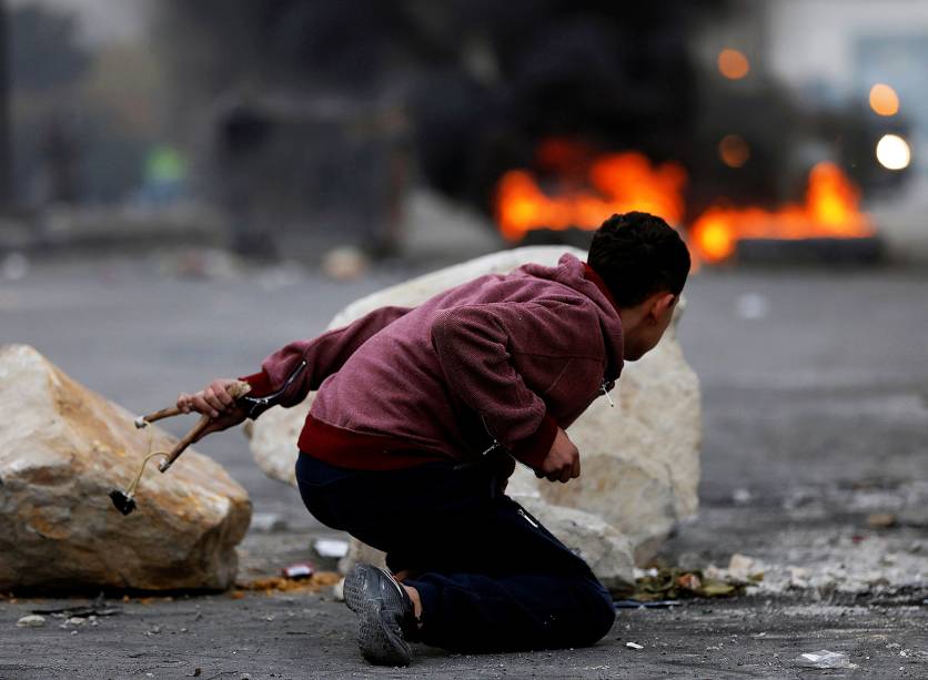 Militante palestino durante o confronto com tropas israelenses na fronteira com a cidade de Gaza - 22/12/2017