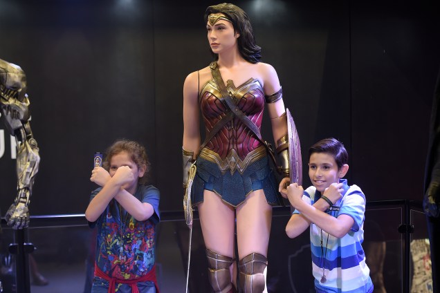 Crianças posam para foto ao lado do boneco em tamanho real da personagem Mulher Maravilha, no estande da Warner durante a Comic Con Experience 2017 - 06/12/2017