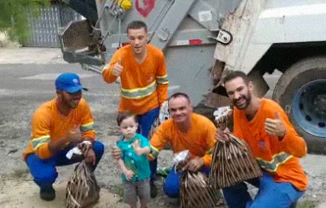 Menino aguarda garis para retirarem lixo