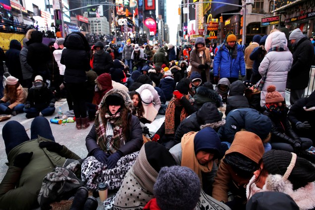 Pedestres se protegem do frio enquanto aguardam a chegada do Ano Novo na Times Square, nos Estados Unidos