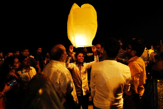 Homem segura lanterna para celebrar o Ano Novo em uma praia de Mumbai, na Índia