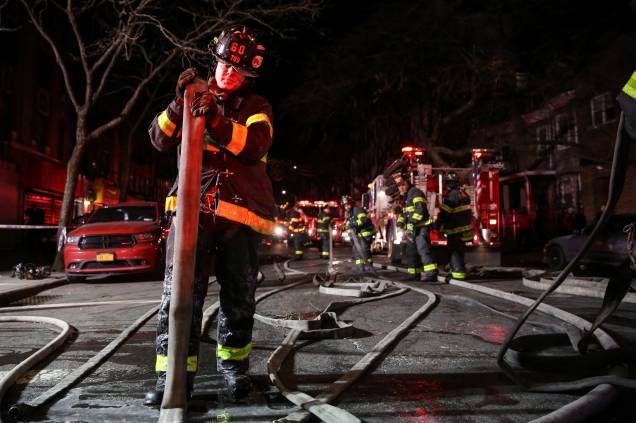 Bombeiros trabalham para controlar um incêndio e resgatar as vítimas em um edifício de apartamentos no bairro do Bronx, em Nova York - 28/12/2017 Bombeiros trabalham para controlar um incêndio e resgatar as vítimas em um edifício de apartamentos no bairro do Bronx, em Nova York - 28/12/2017