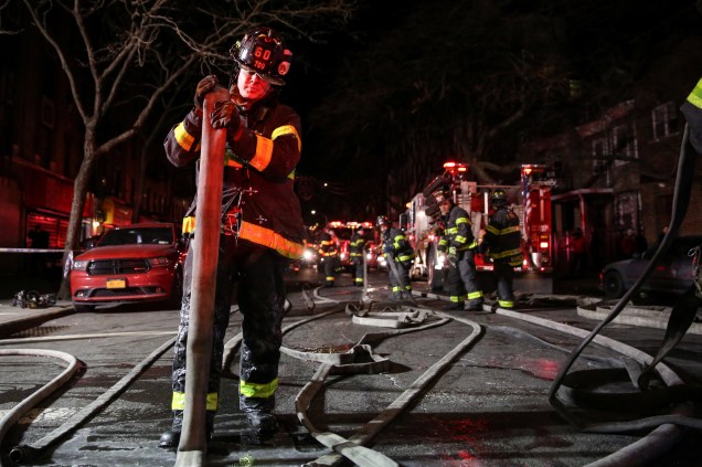 Bombeiros trabalham para controlar um incêndio e resgatar as vítimas em um edifício de apartamentos no bairro do Bronx, em Nova York - 28/12/2017