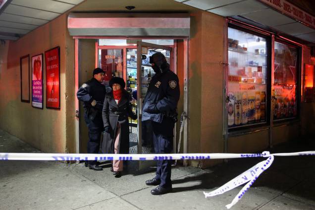 Policiais auxiliam a saída de moradores de um edifício de apartamentos durante incêndio no bairro do Bronx, em Nova York - 28/12/2017 Policiais auxiliam a saída de moradores de um edifício de apartamentos durante incêndio no bairro do Bronx, em Nova York - 28/12/2017