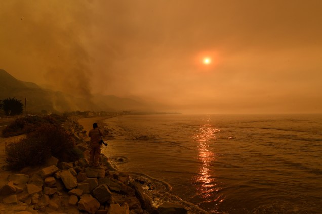 Densa nuvem de fumaça cobre o enclave à beira-mar da praia de Mondos, ao lado de uma estrada enquanto as chamas chegam à costa durante o incêndio Thomas Fire perto de Ventura, na Califórnia - 06/12/2017