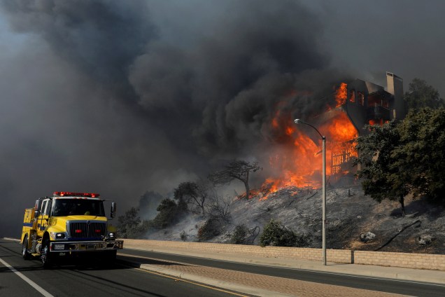 Caminhão de combate a incêndios passa por uma casa em chamas durante em Ventura, na Califórnia - 05/12/2017