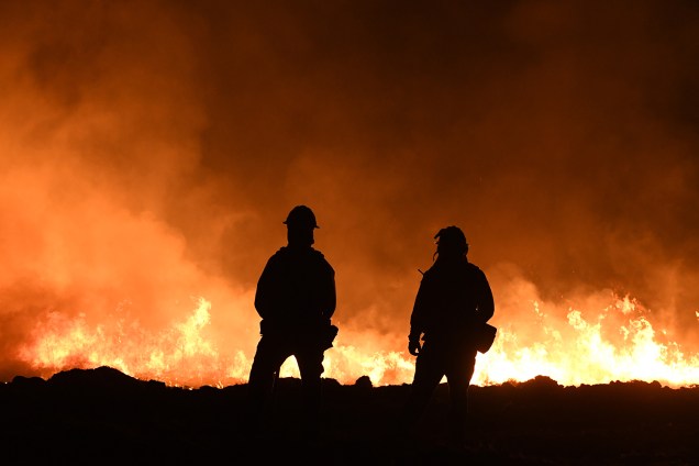 Bombeiros acendem lanternas durante trabalho de rescaldo de incêndio florestal em Ojai, no estado americano da Califórnia - 09/12/2017