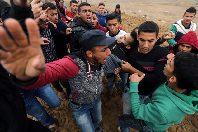 Palestino ferido é carregado durante confronto com tropas israelenses em um protesto contra a decisão do presidente dos EUA, Donald Trump, de reconhecer Jerusalém como a capital de Israel, perto da fronteira com Israel, no sul da Faixa de Gaza - 07/12/2017