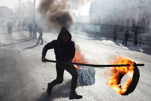 Manifestante palestino faz barricada com pneus na cidade de Belém, região da Cisjordânia, durante protestos contra a decisão do presidente dos Estados Unidos, Donald Trump, de reconhecer Jerusalém como a capital de Israel - 10/12/2017