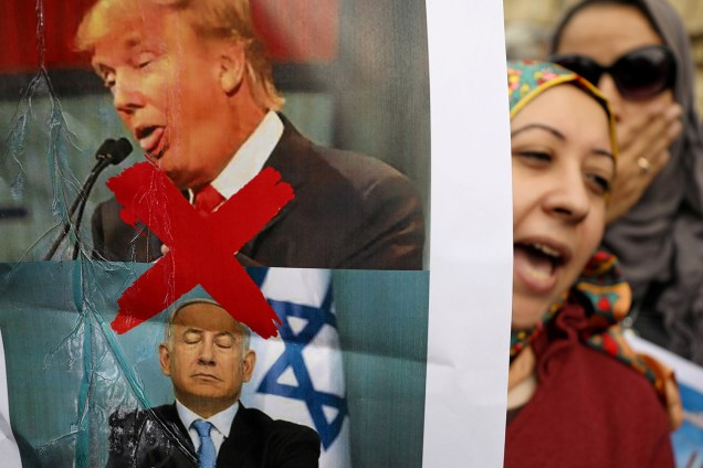 Manifestantes exibem cartaz com os rostos de Donald Trump e Benjamin Netanyahu - presidente dos Estados Unidos e primeiro-ministro israelense - durante protestos realizados em Cairo, no Egito, contra a decisão do líder americano de reconhecer Jerusalém como a capital de Israel - 10/12/2017