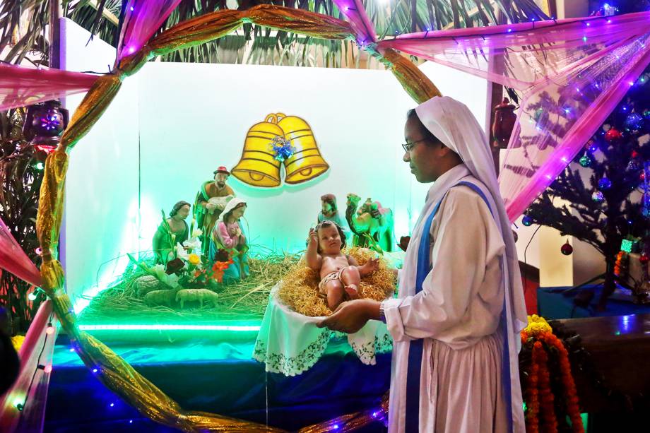 Freira segura Jesus Cristo em uma manjedoura na Catedral de Santa Maria, em Daca, capital de Bangladesh - 24/12/2017