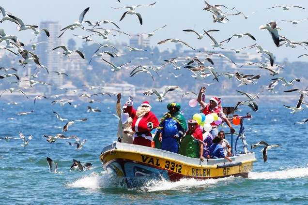 Homem vestido de Papai Noel acena para pessoas em um barco de pescadores, na costa de Valparaíso, no Chile - 24/12/2017