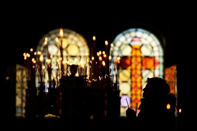 Mulher acende velas durante missa de Natal realizada na catedral de Alexander Nevski, em Sófia, capital da Bulgária - 25/12/2017