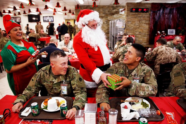 Membro do Exército americano recebe presente de homem vestido de Papai Noel, durante as celebrações de Natal em Cabul, no Afeganistão - 25/12/2017