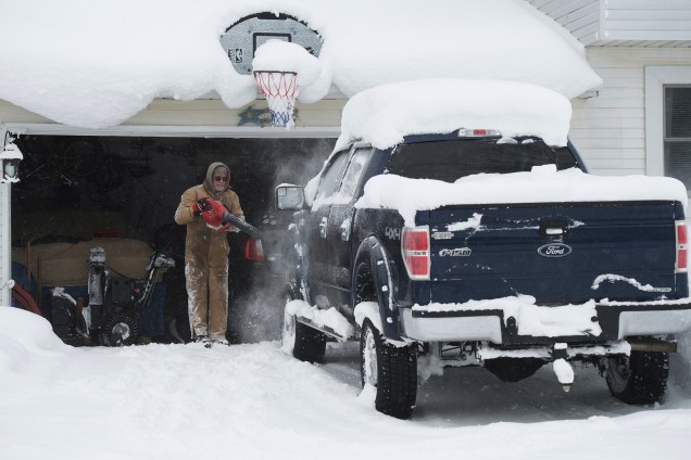 Um homem utiliza o soprador para retirar a neve de cima da sua caminhonete, em Erie, na Pensilvânia - 27/12/2017
