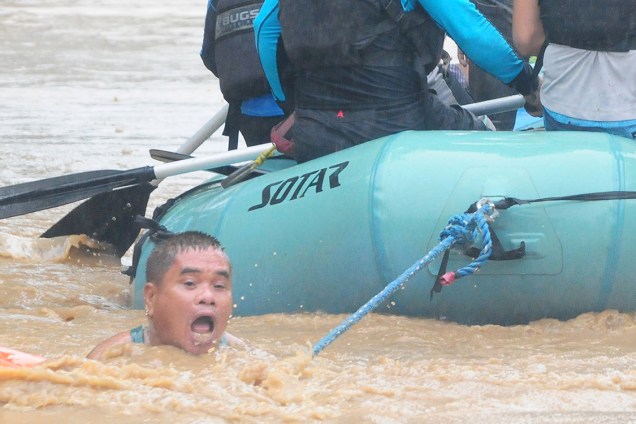 Homem é resgatado por bote das forças armadas durante enchente causada por tempestade em Cagayan de Oro, nas Filipinas - 23/12/2017