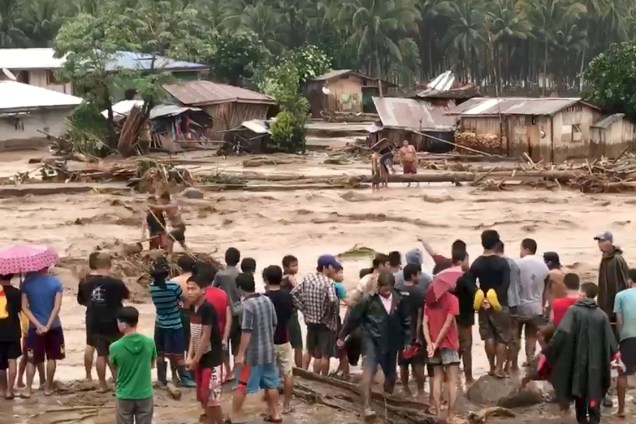 Pessoas ajudam no resgate de vítimas de tempestade que atingiu a região de Lanao del Norte, nas Filipinas - 23/12/2017