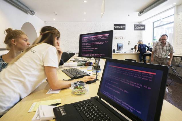 Empregados de uma loja de Kiev, na Ucrânia, observam mensagem em computador, deixada pelo vírus Wannacry, ciberataque que afetou 300 mil computadores e paralisou grandes órgãos pelo mundo, inclusive no Brasil, como o Ministério Público do Estado de São Paulo, o TJSP, o INSS e diversos bancos - 12/05/2017 Empregados de uma loja de Kiev, na Ucrânia, observam mensagem em computador, deixada pelo vírus Wannacry, ciberataque que afetou 300 mil computadores e paralisou grandes órgãos pelo mundo, inclusive no Brasil, como o Ministério Público do Estado de São Paulo, o TJSP, o INSS e diversos bancos - 12/05/2017