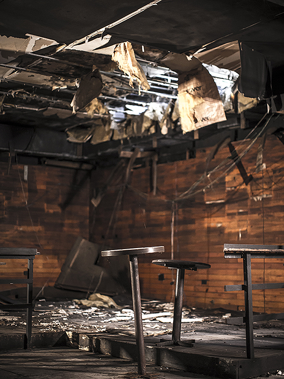 As chuvas e o clima acabaram de destruir o teto enfraquecido pelas chamas. As mesas, antes fixas no chão, pendem para os lados, ao lado de um dos bares da boate