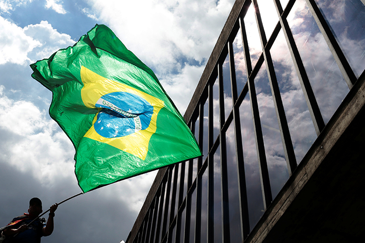 Homem segura bandeira durante protesto contra o ex-presidente Lula, em frente ao MASP, na Avenida Paulista - 24/01/2018