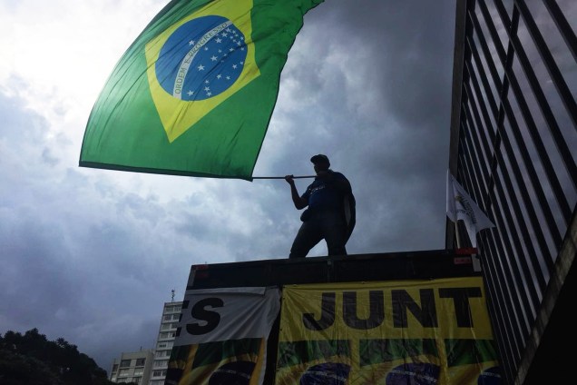Homem balança uma bandeira do Brasil durante ato a favor  da condenação do ex-presidente Lula em frente ao MASP, na Avenida Paulista, em São Paulo - 24/01/2018