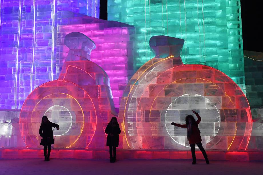 Visitantes posam para fotos na frente de uma escultura de gelo no dia de abertura do Festival Anual de Escultura de Gelo e Neve de Harbin, no nordeste da China - 05/01/2018