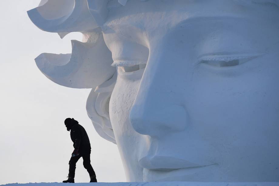 Um trabalhador é visto andando sobre uma escultura de neve antes da abertura do Festival Anual de Escultura de Gelo e Neve de Harbin, no nordeste da China - 05/01/2018