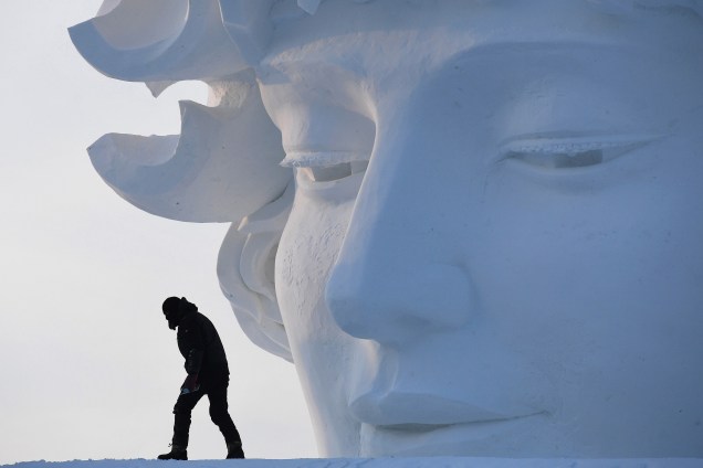 Um trabalhador é visto andando sobre uma escultura de neve antes da abertura do Festival Anual de Escultura de Gelo e Neve de Harbin, no nordeste da China - 05/01/2018