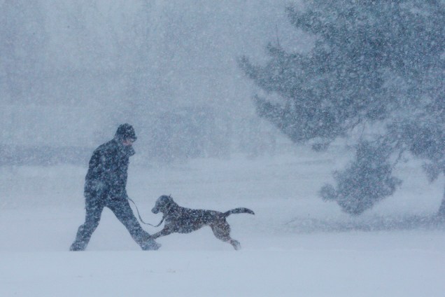 Um homem e seu cão brincam na neve durante uma tempestade de neve em Revere, no subúrbio de Boston, Massachusetts - 04/01/2018