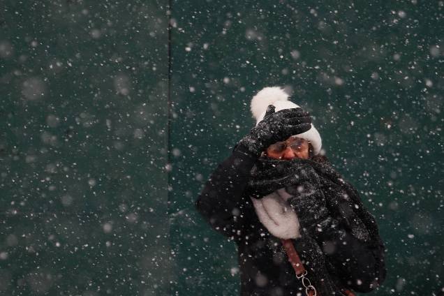 Mulher é vista cobrindo o rosto para se proteger da neve na Times Square, em Nova York - 04/01/2018 Mulher é vista cobrindo o rosto para se proteger da neve na Times Square, em Nova York - 04/01/2018