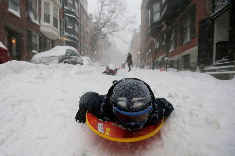 Garotos brincam com skys na neve pela rua Beacon Hill, em Boston, Massachusetts - 04/01/2018
