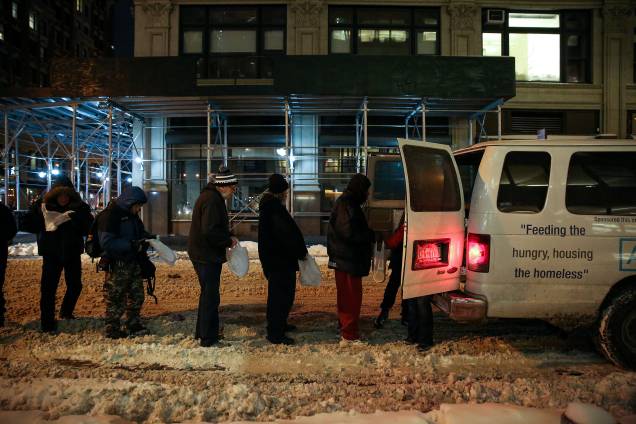 Moradores de rua aguardam na fila enquanto a Coalizão da Cidade de Nova Iorque para os Sem-Abrigo entrega comida, roupas e suprimentos para pessoas sem-teto como parte de sua distribuição semanal durante a tempestade de inverno Grayson em Manhattan, Nova York - 04/01/2018 Moradores de rua aguardam na fila enquanto a Coalizão da Cidade de Nova Iorque para os Sem-Abrigo entrega comida, roupas e suprimentos para pessoas sem-teto como parte de sua distribuição semanal durante a tempestade de inverno Grayson em Manhattan, Nova York - 04/01/2018