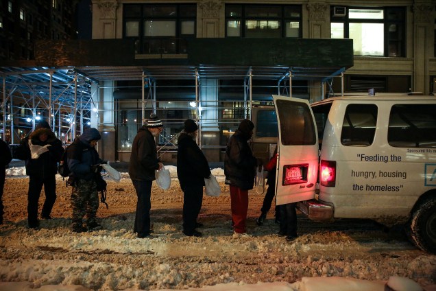 Moradores de rua aguardam na fila enquanto a Coalizão da Cidade de Nova Iorque para os Sem-Abrigo entrega comida, roupas e suprimentos para pessoas sem-teto como parte de sua distribuição semanal durante a tempestade de inverno Grayson em Manhattan, Nova York - 04/01/2018