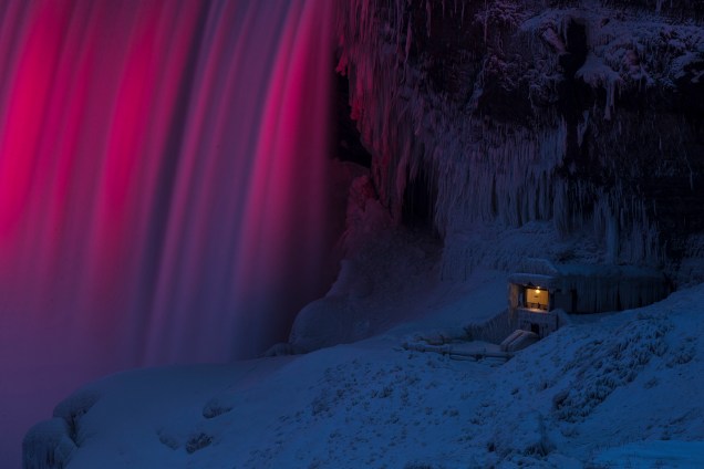 Um dos pontos de observação das Cataratas do Niagara, em Ontario, no Canadá, é visto coberto de gelo. Ao lado, luzes iluminam a queda d'água - 10/01/2018