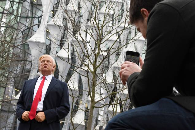 Pedestres tiram fotos de uma estátua de cera Madame Tussauds do presidente Donald Trump, do lado de fora da nova embaixada dos Estados Unidos em Embassy Gardens, no sudoeste de Londres - 12/01/2018 Pedestres tiram fotos de uma estátua de cera Madame Tussauds do presidente Donald Trump, do lado de fora da nova embaixada dos Estados Unidos em Embassy Gardens, no sudoeste de Londres - 12/01/2018